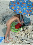 Spying on a nude gal taking a tan and enjoying the sea